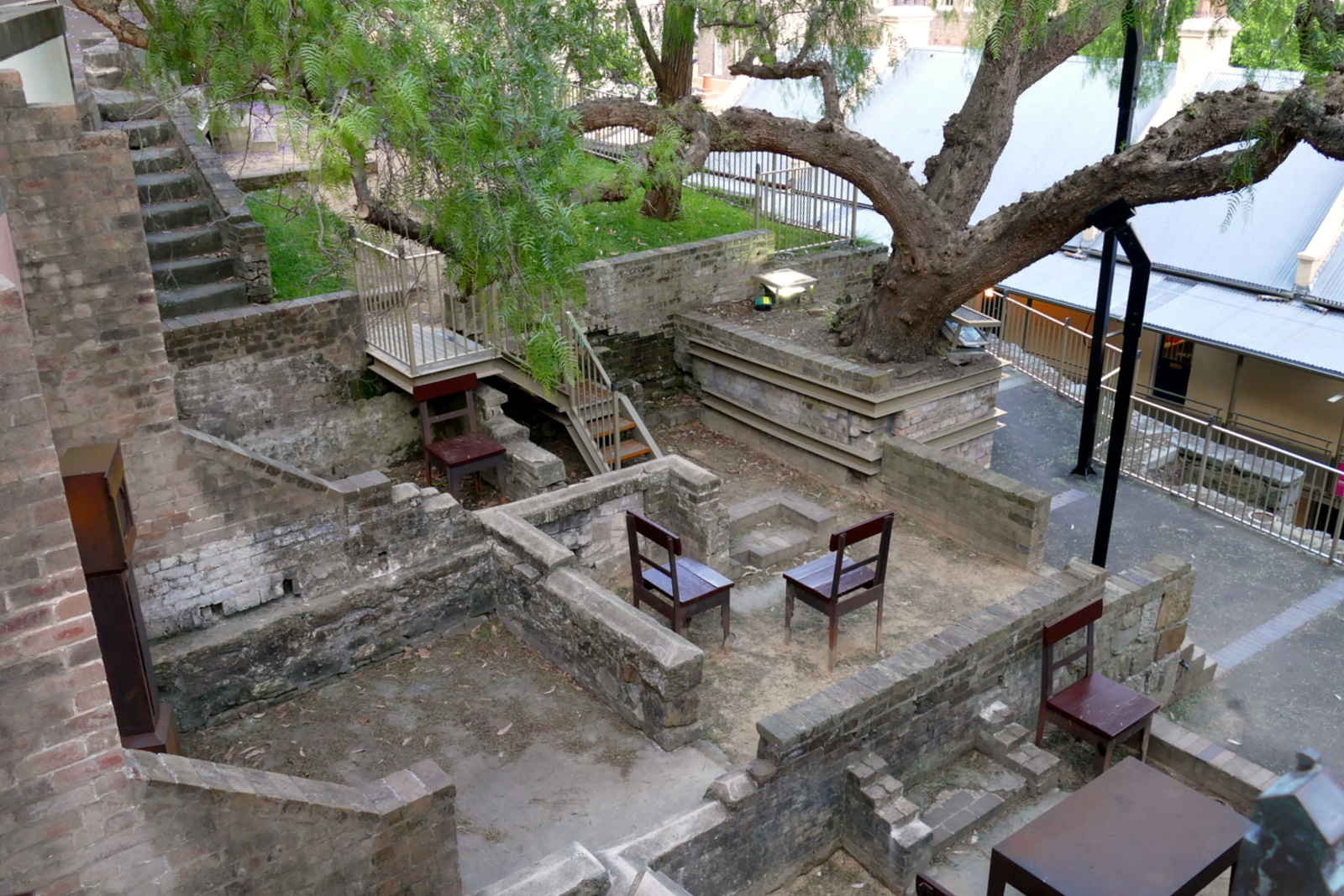 Some ruins in the Rocks area. Chairs are put in place to show the cramped quarters in the old convicts homes.