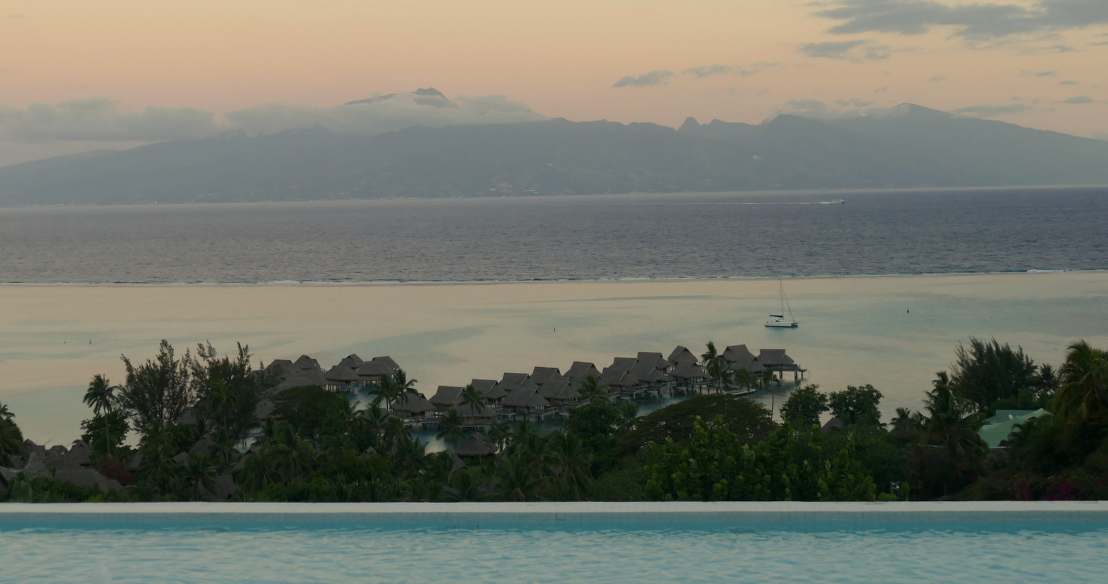 An evening view of the pool (closest), then Sofitel bungalows, then lagoon, then channel between islands, then Tahiti.